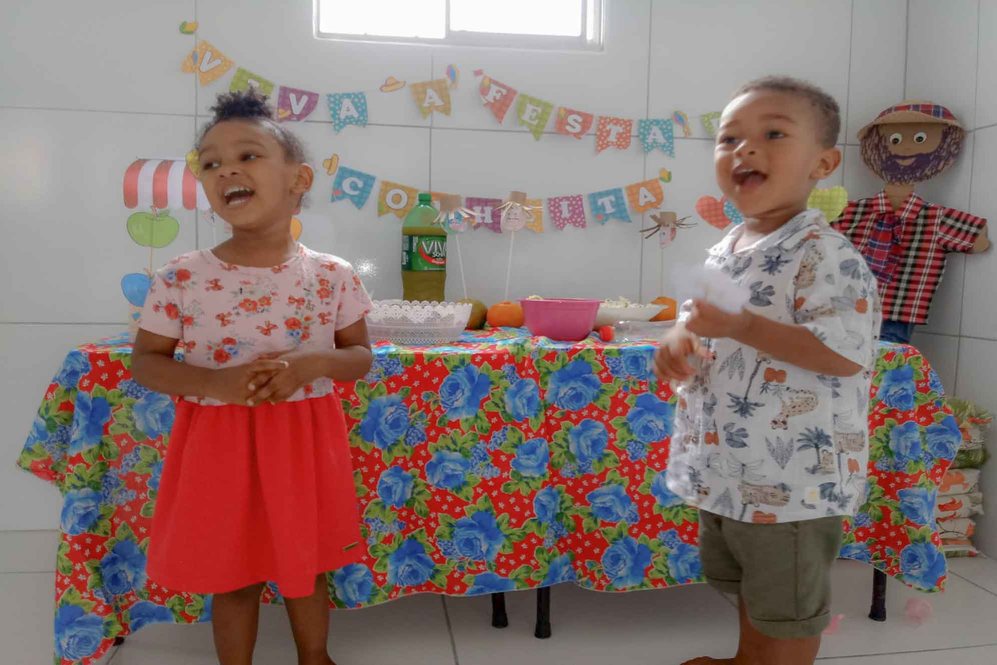 Foto de um menino e uma menina sorrindo na